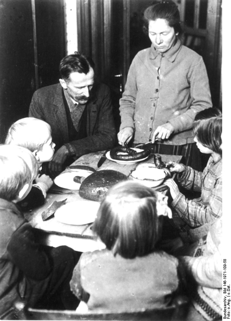 Eine Familie teilt sich eine einzige Wurst als Abendessen (ca. 1920)